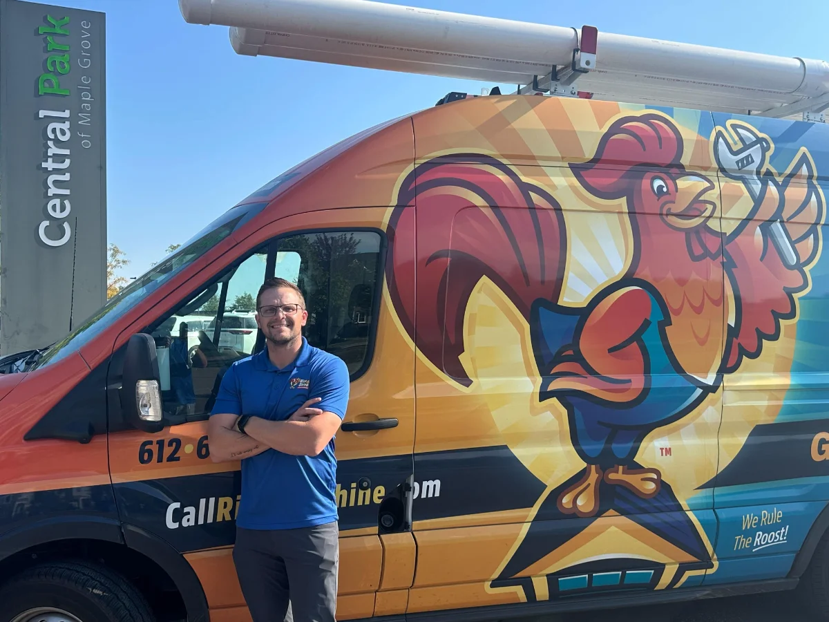 Alex, owner of Rise & Shine Garage Doors, standing in front of his van in Central Park of Maple Grove, MN.