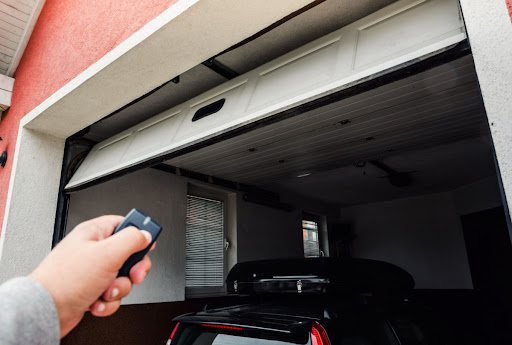 Person opening their garage door with their remote opener
