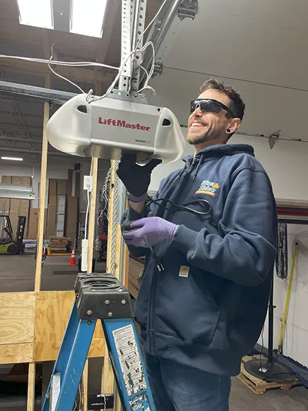Technician smiling while installing Lift Master opener.