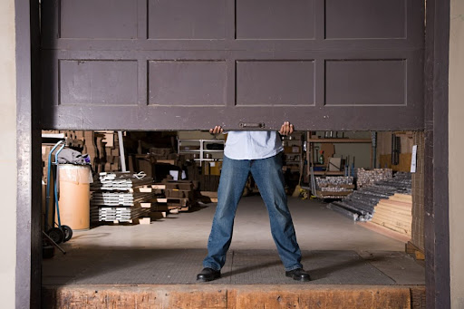Man trying to open a stuck garage door manually